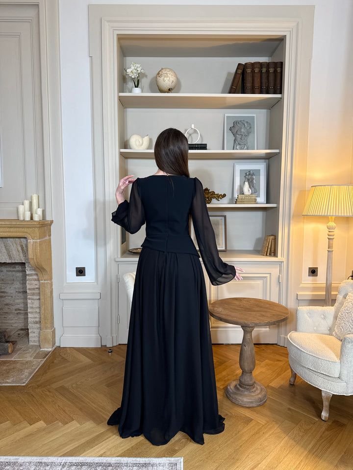 Robe de soirée noir élégante avec col rond et manches longues, coupe fluide sans fente. Une robe chic et intemporelle pour vos soirées.
