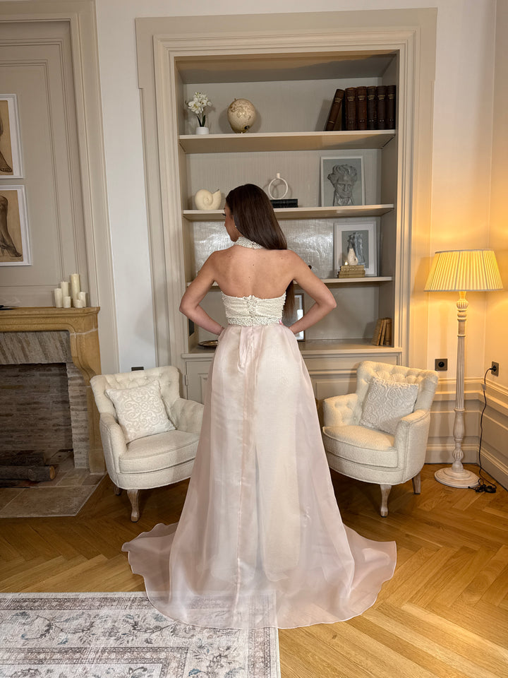 Longue robe de soirée beige élégante, col bustier sans manches, coupe fluide sans fente. Une robe raffinée pour vos soirées chic.