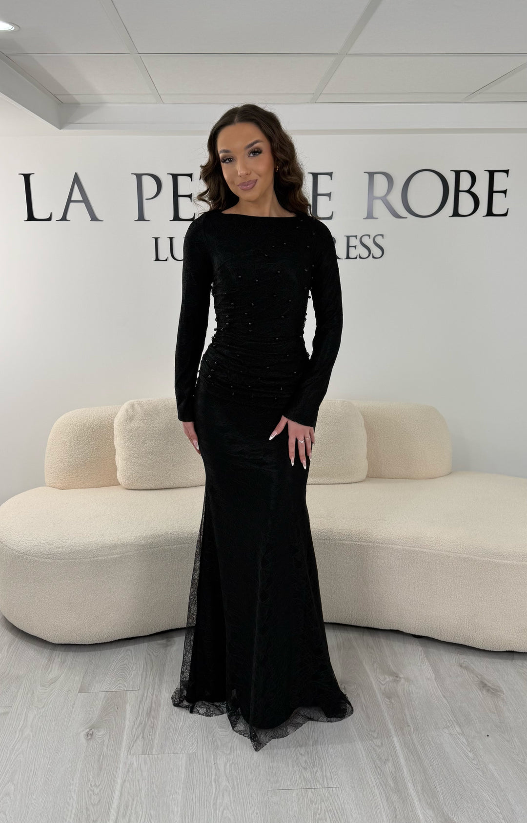 Robe de soirée noire longue en dentelle perlée avec manches longues et col rond légèrement montant. Sans fente, idéale mariage et demoiselle d’honneur 2026.