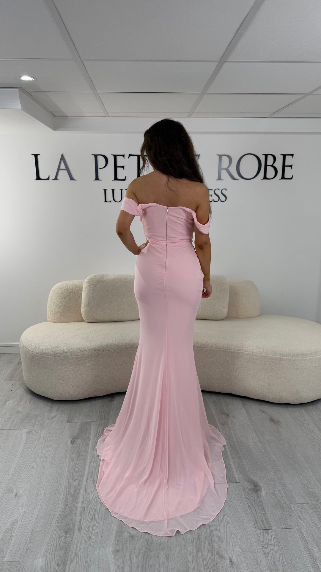 Robe de soirée rose élégante avec drapé et épaules dénudées. Coupe longue sans fente, parfaite pour une soirée chic.