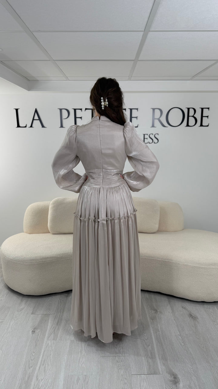 Robe de soirée modeste beige élégante avec manches longues et plissé. Coupe longue sans fente, parfaite pour une tenue chic.