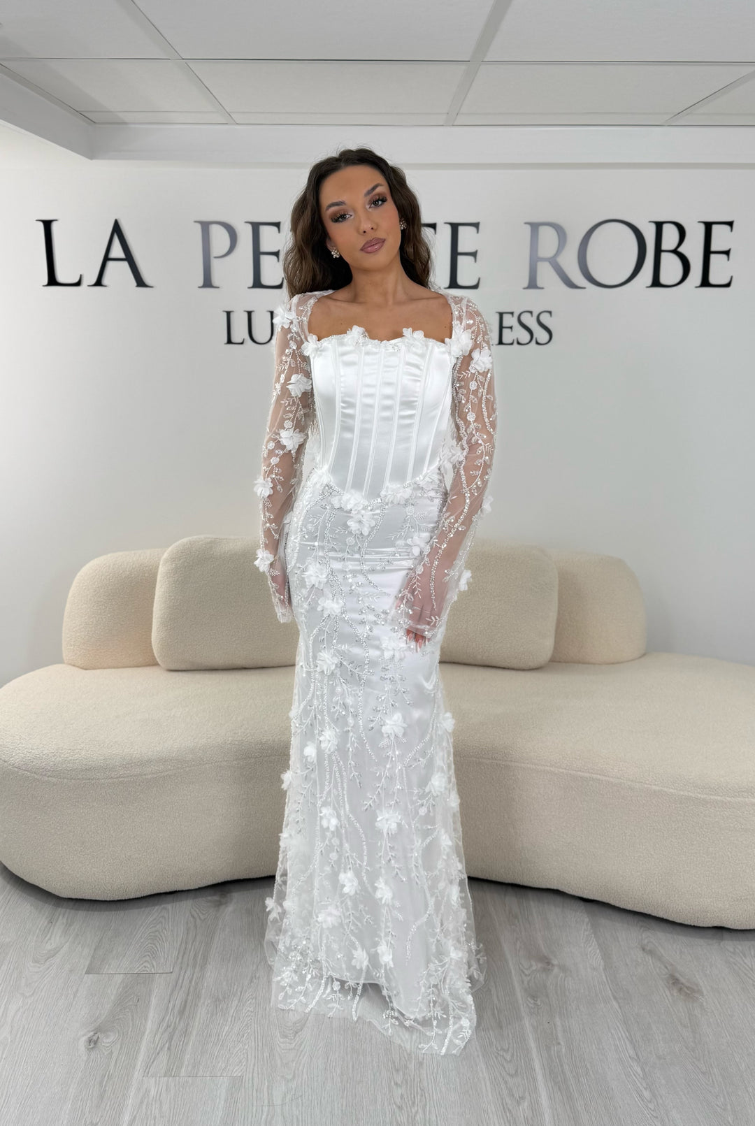 Robe de mariée blanche élégante avec dentelle et corset. Coupe longue sans fente, idéale pour une cérémonie chic.