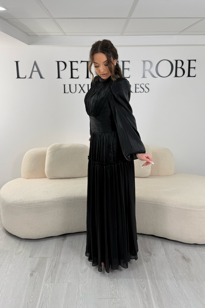 Robe de soirée modeste noire élégante avec manches longues et plissé. Coupe longue sans fente, parfaite pour une tenue chic.