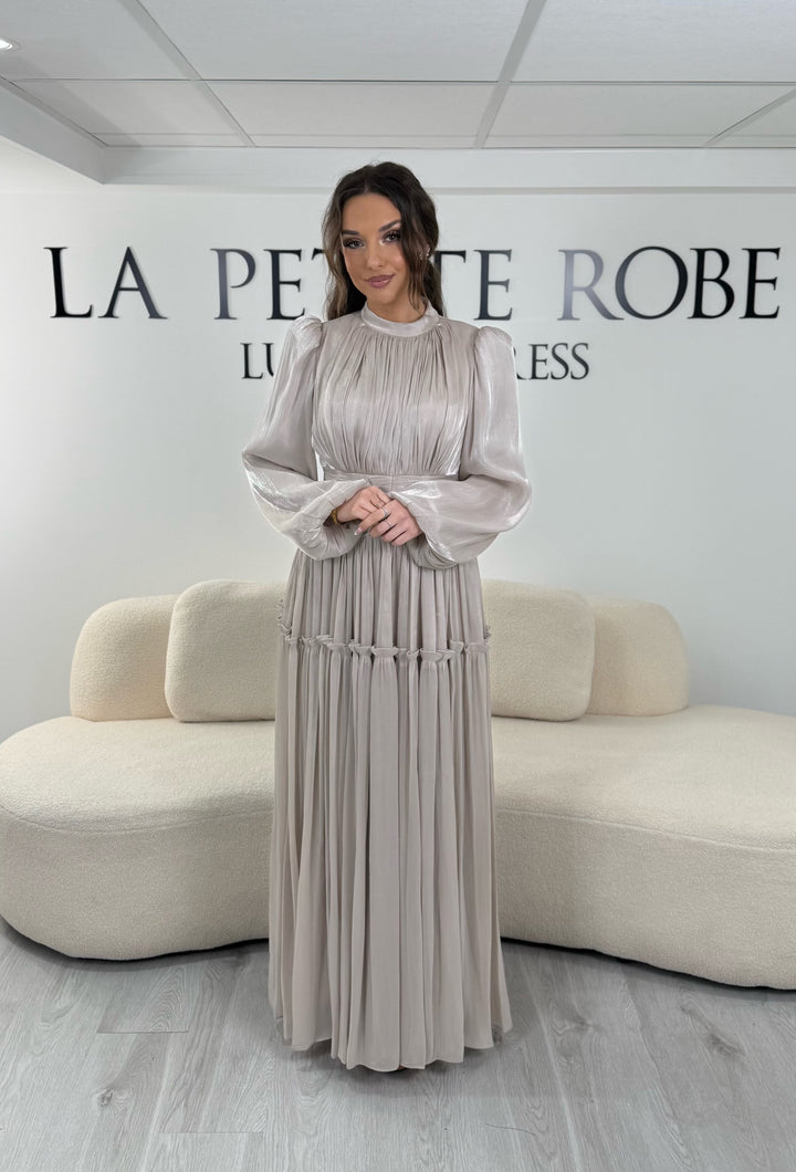 Robe de soirée modeste beige élégante avec manches longues et plissé. Coupe longue sans fente, parfaite pour une tenue chic.