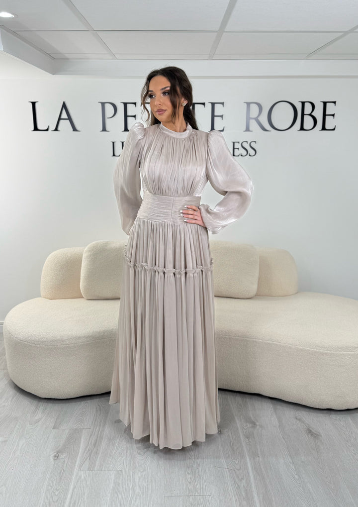 Robe de soirée modeste beige élégante avec manches longues et plissé. Coupe longue sans fente, parfaite pour une tenue chic.