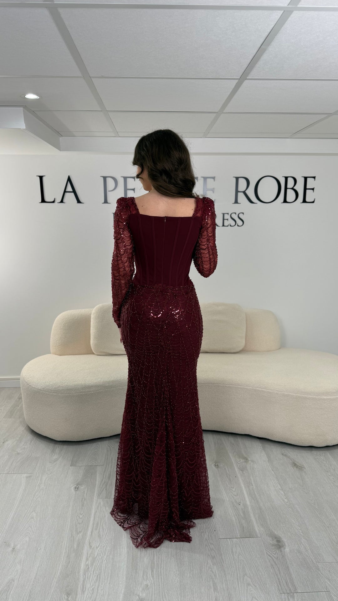 Robe de soirée bordeaux élégante sans fente, avec manches longues et détails scintillants. Parfaite pour un look chic et sophistiqué.