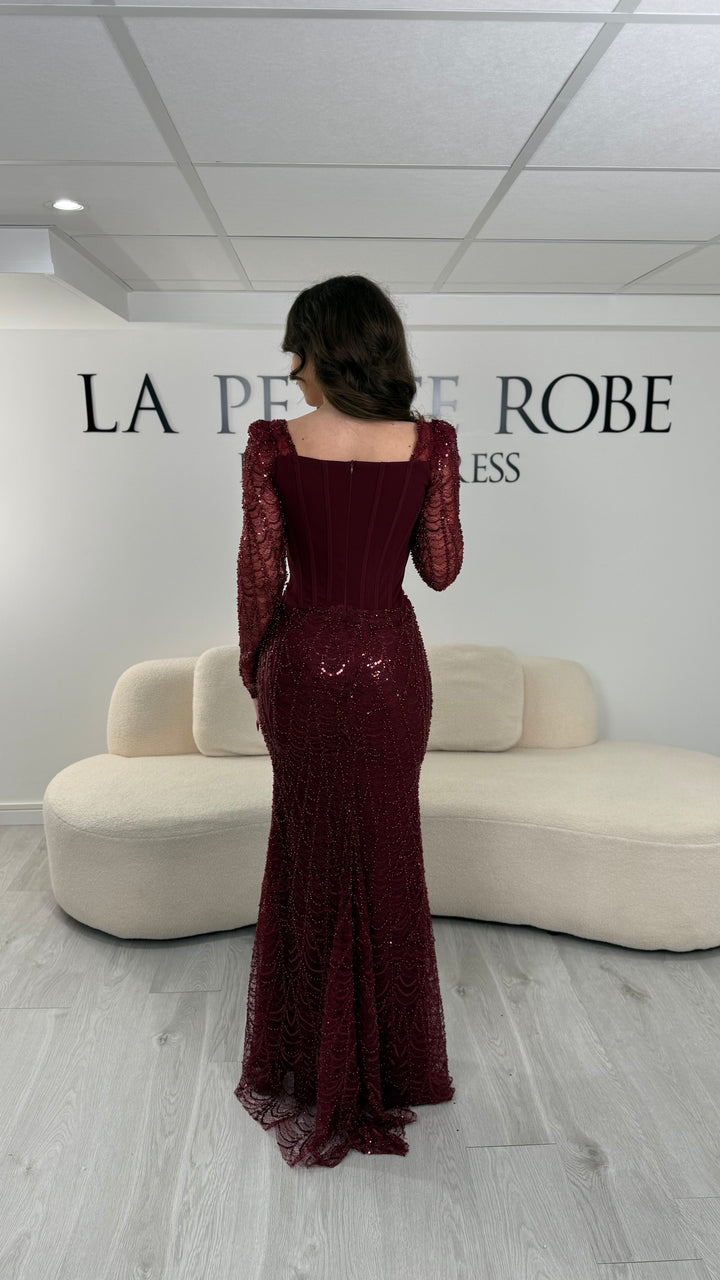Robe de soirée bordeaux élégante sans fente, avec manches longues et détails scintillants. Parfaite pour un look chic et sophistiqué.