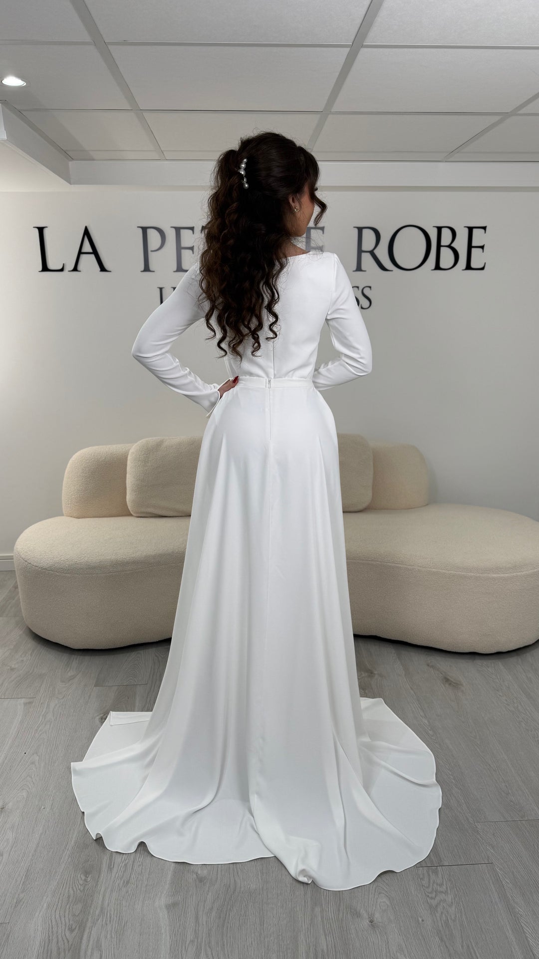 Robe de mariée blanche élégante avec col carré, manches longues et traîne amovible sans fente. Idéale pour un look chic et raffiné.