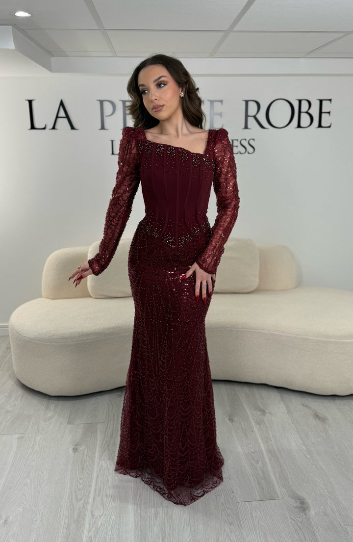 Robe de soirée bordeaux élégante sans fente, avec manches longues et détails scintillants. Parfaite pour un look chic et sophistiqué.
