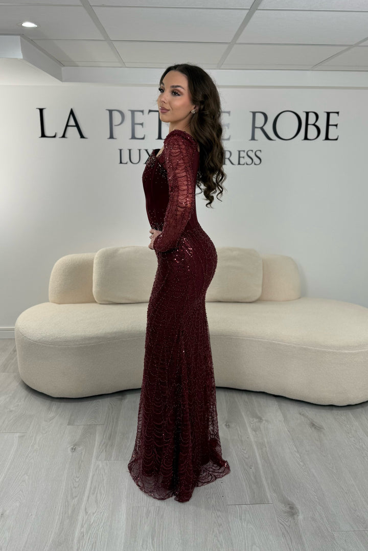 Robe de soirée bordeaux élégante sans fente, avec manches longues et détails scintillants. Parfaite pour un look chic et sophistiqué.
