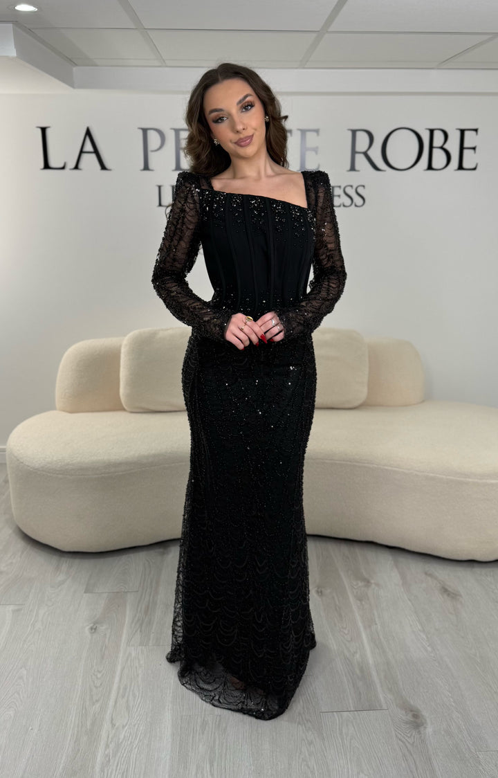 Robe de soirée noire élégante sans fente, avec manches longues et détails scintillants. Parfaite pour un look chic et sophistiqué.