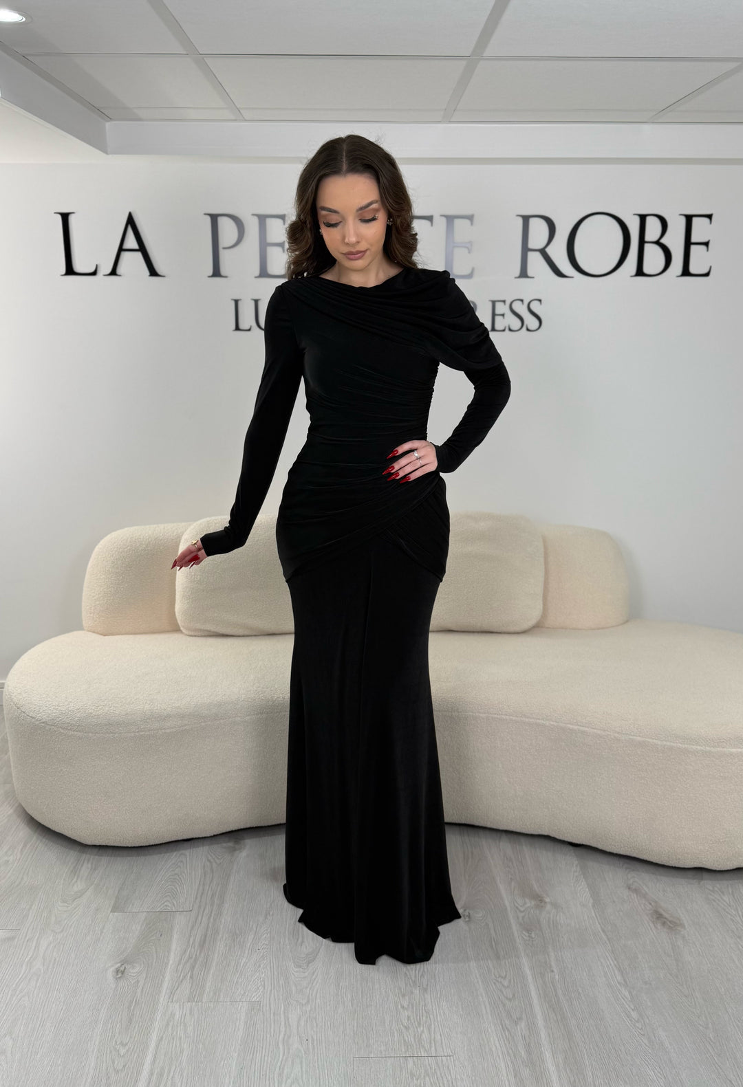 Robe de soirée noire en jersey stretch élégante, sans fente, avec manches longues et coupe fluide. Idéale pour un look chic et confortable.