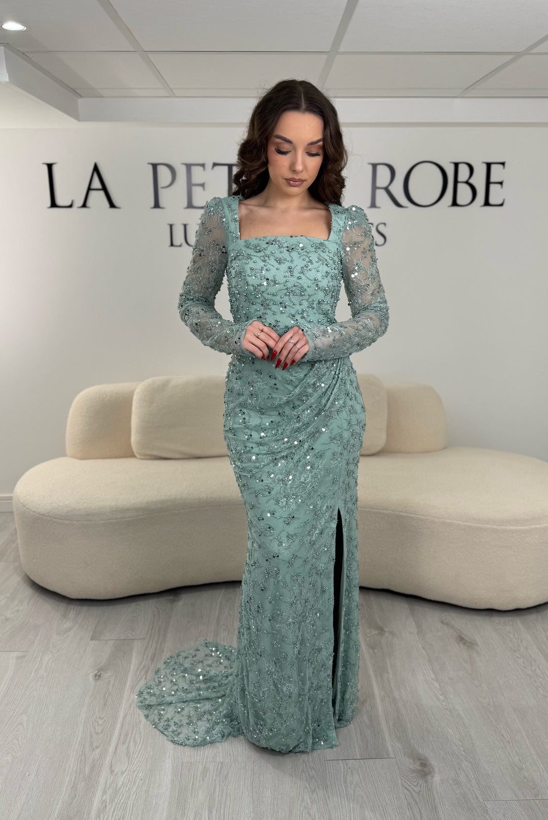 Robe de soirée vert d’eau élégante avec col carré, manches longues et fente glamour. Idéale pour un look chic, lumineux et raffiné.