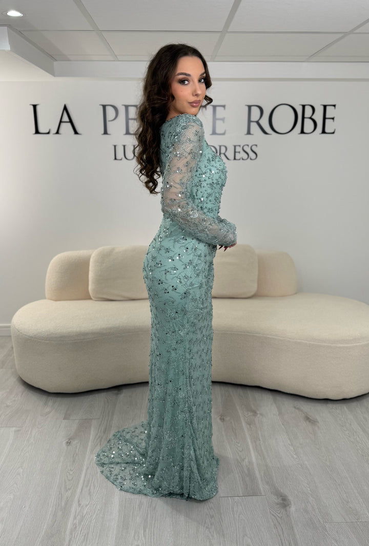 Robe de soirée vert d’eau élégante avec col carré, manches longues et fente glamour. Idéale pour un look chic, lumineux et raffiné.