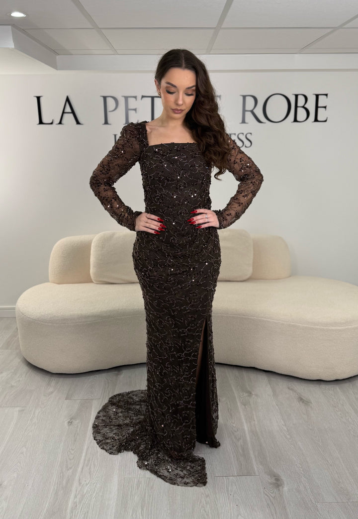 Robe de soirée marron élégante avec col carré, manches longues et fente glamour. Idéale pour un look chic, lumineux et raffiné.