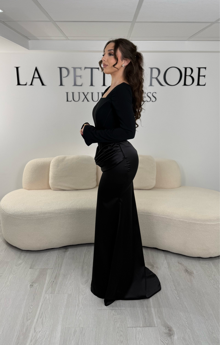 Robe de soirée noire élégante avec col carré, manches longues et coupe ajustée sans fente. Idéale pour un look chic et raffiné.