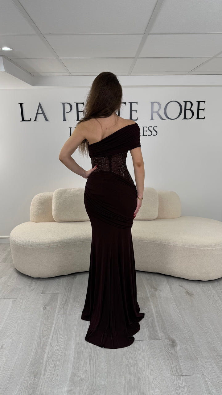 Robe de soirée marron en jersey stretch, sans manche avec col asymétrique. Coupe ajustée sans fente, idéale pour une allure élégante et moderne.