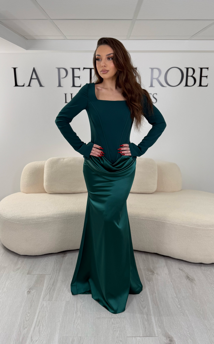 Robe de soirée vert émeraude avec col carré, manches longues et corset structuré. Coupe ajustée sans fente avec drapé élégant, idéale pour une allure chic.