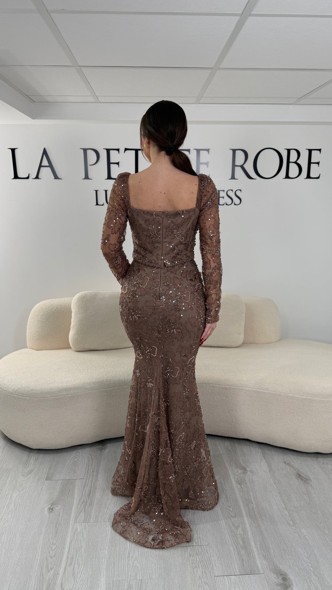 Robe de soirée marron coupe sirène avec col carré et manches longues. Sans fente, avec broderies et drapé élégant pour une allure raffinée.