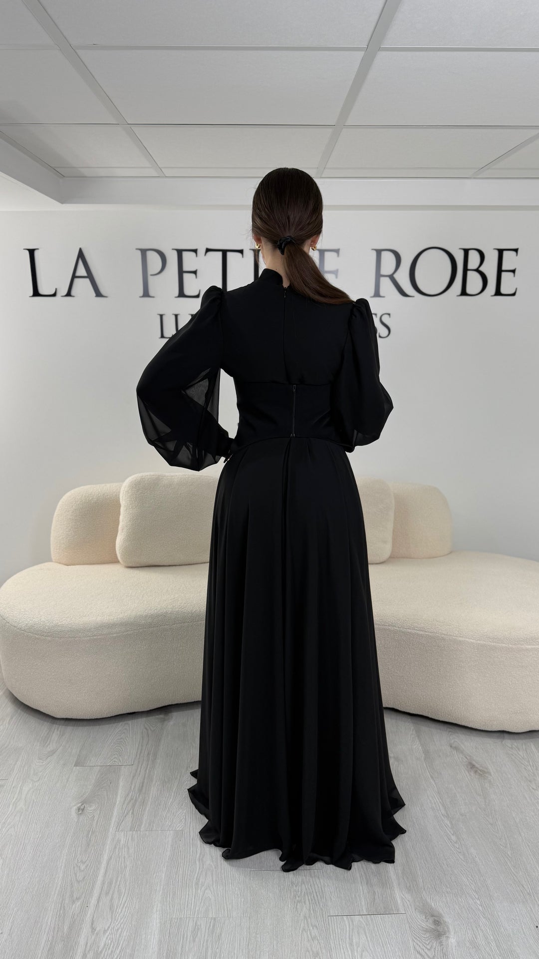 Robe de soirée modeste noire avec manches longues et col montant. Coupe fluide sans fente, idéale pour une allure élégante et sophistiquée.