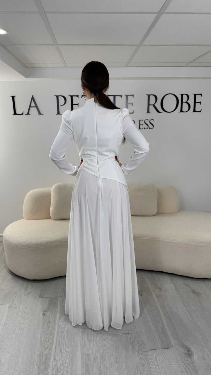 Robe de mariée modeste blanche avec manches longues et col montant. Coupe fluide sans fente, idéale pour une allure élégante et raffinée.