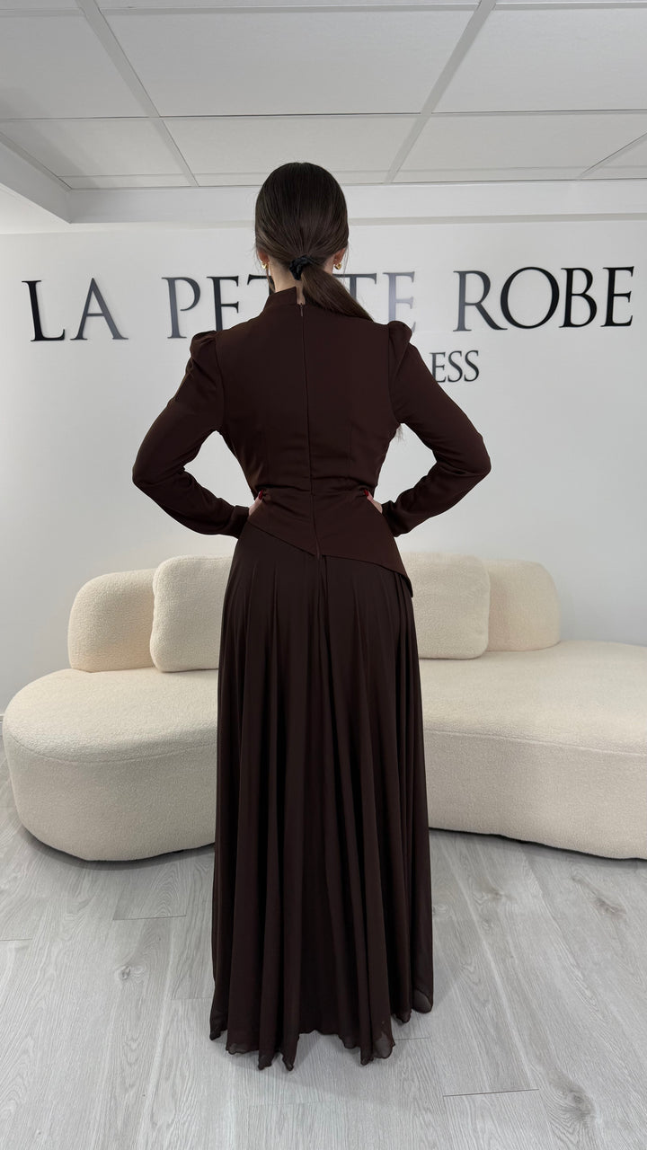 Robe de soirée marron avec manches longues et col montant. Coupe fluide sans fente, idéale pour une allure élégante et sophistiquée.