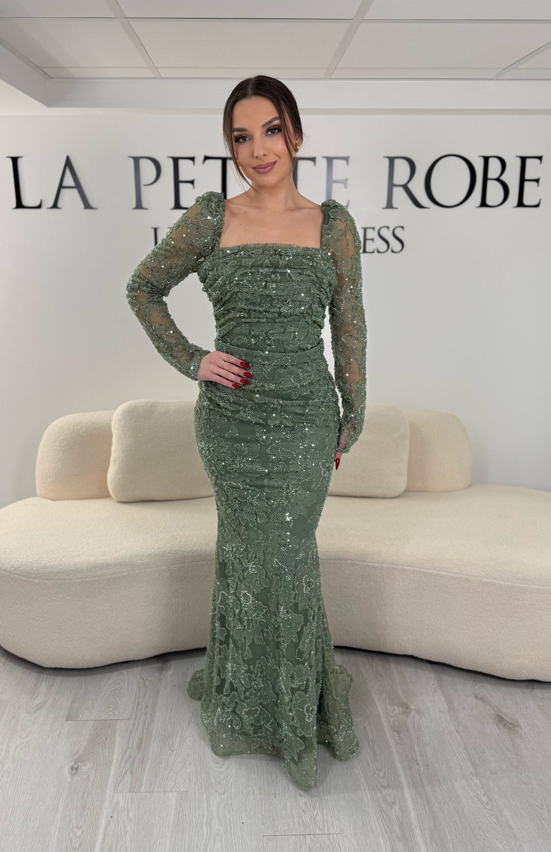 Robe de soirée vert d’eau coupe sirène avec col carré et manches longues. Sans fente, avec broderies et drapé élégant pour une allure raffinée.