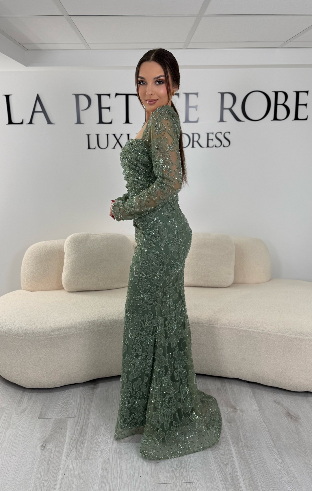 Robe de soirée vert d’eau coupe sirène avec col carré et manches longues. Sans fente, avec broderies et drapé élégant pour une allure raffinée.