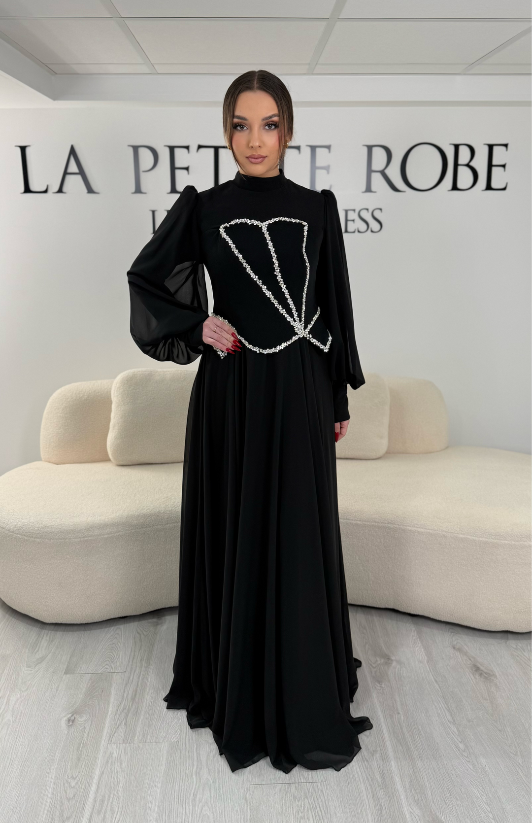 Robe de soirée modeste noire avec manches longues et col montant. Coupe fluide sans fente, idéale pour une allure élégante et sophistiquée.