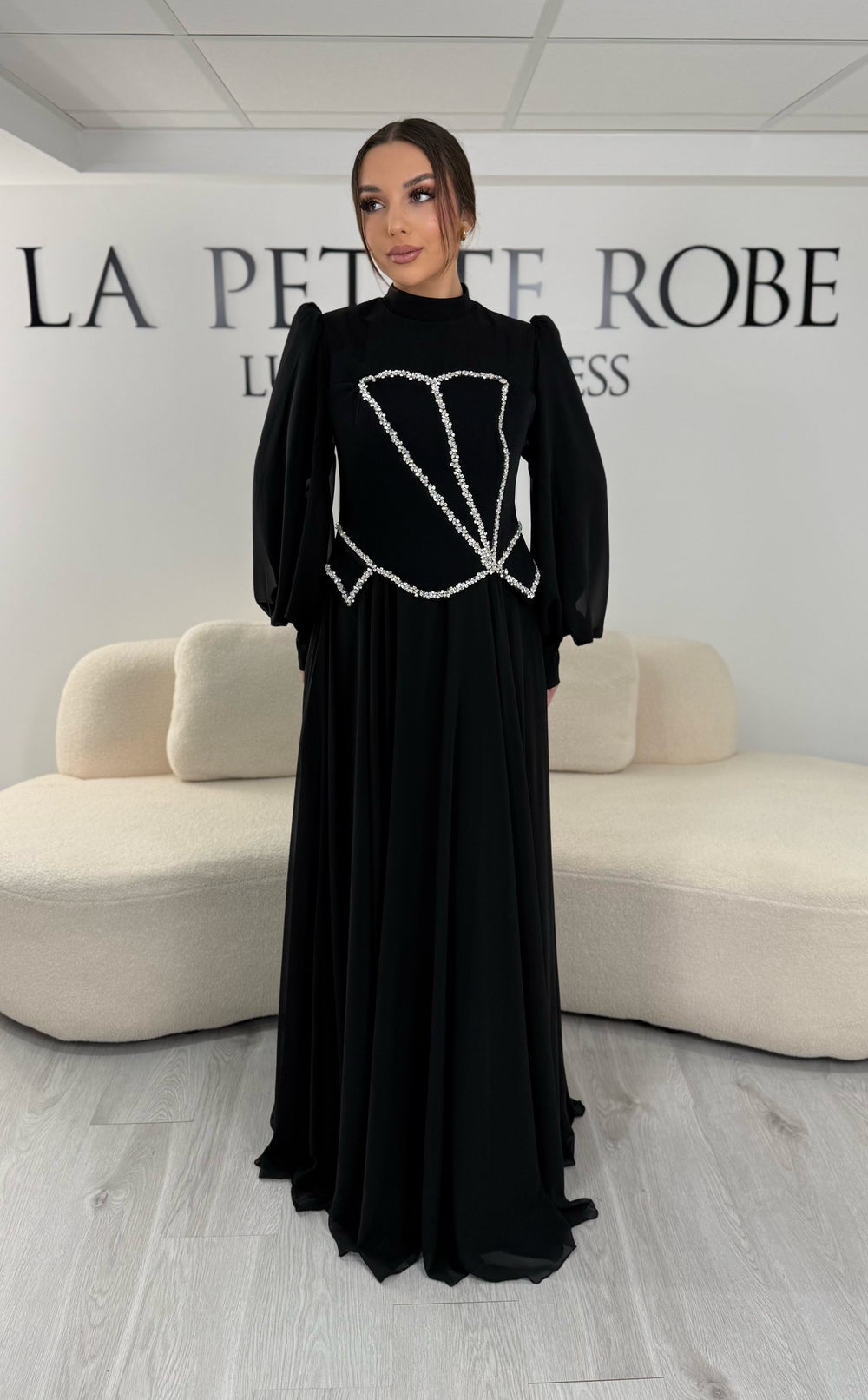 Robe de soirée modeste noire avec manches longues et col montant. Coupe fluide sans fente, idéale pour une allure élégante et sophistiquée.