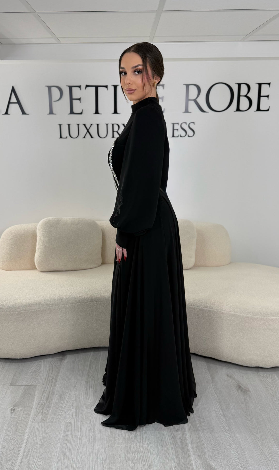 Robe de soirée modeste noire avec manches longues et col montant. Coupe fluide sans fente, idéale pour une allure élégante et sophistiquée.