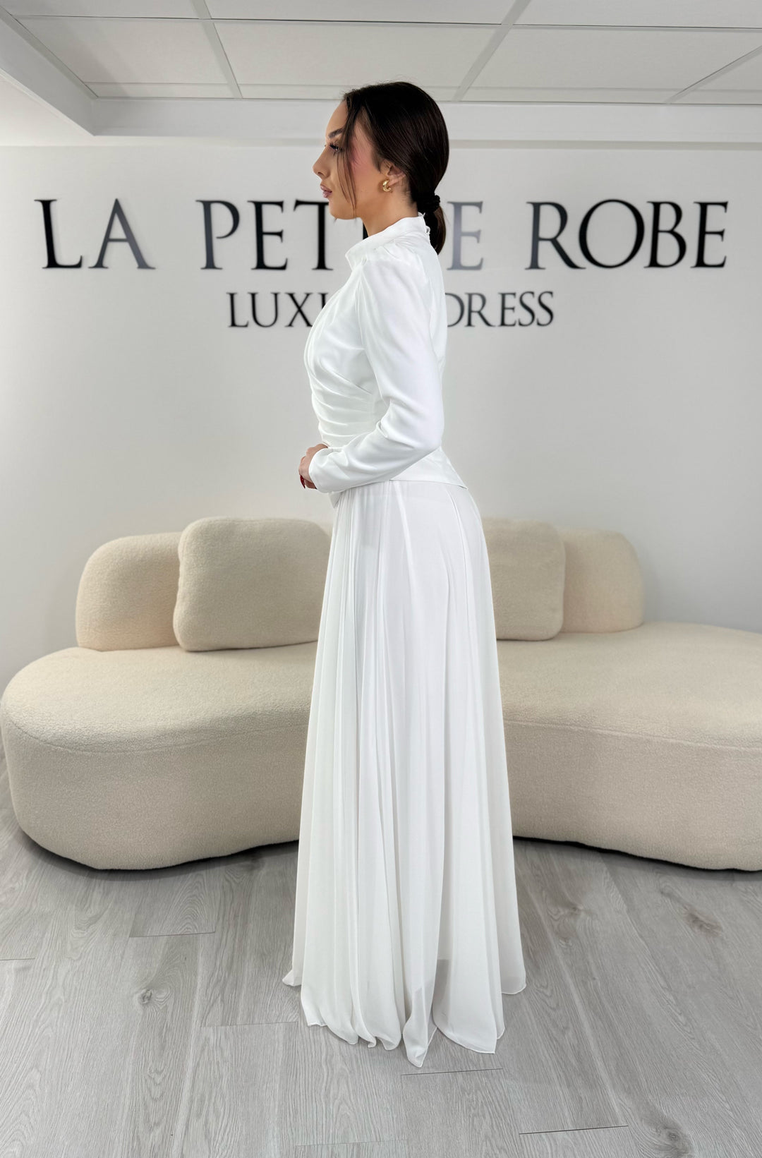 Robe de mariée modeste blanche avec manches longues et col montant. Coupe fluide sans fente, idéale pour une allure élégante et raffinée.