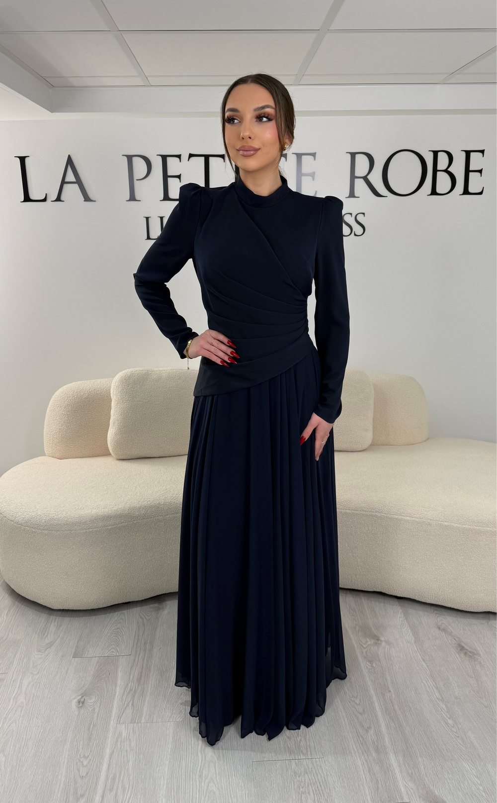 Robe de soirée bleu marine avec manches longues et col montant. Coupe fluide sans fente, idéale pour une allure élégante et sophistiquée.