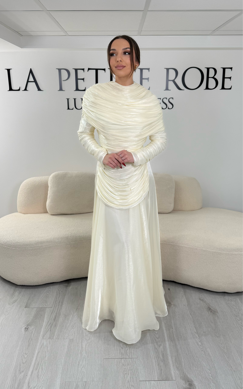 Robe de soirée modeste crème avec manches longues et drapé élégant. Coupe fluide sans fente, idéale pour une allure chic et raffinée.