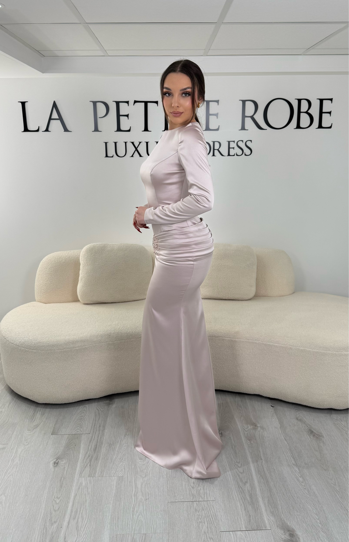 Robe de soirée rose avec manches longues et coupe ajustée. Sans fente, tissu satiné et détails élégants pour une allure sophistiquée.