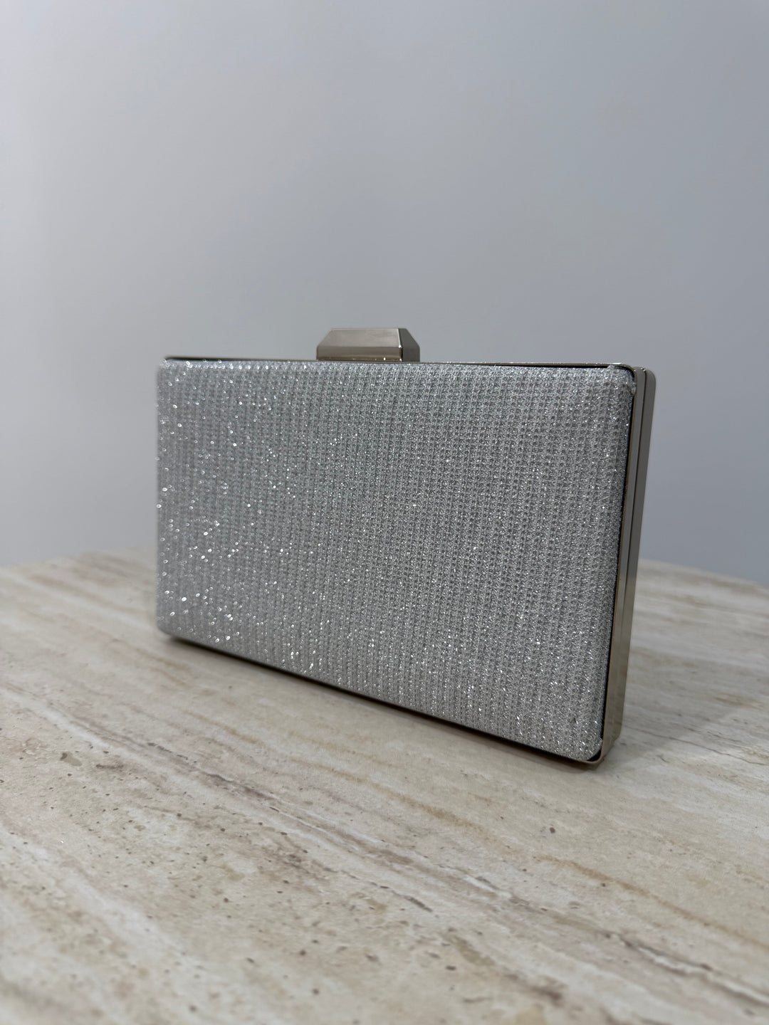 Pochette de soirée argentée pailletée élégante avec anse main et bandoulière chaîne. Idéale pour mariage, cérémonie et soirée chic.