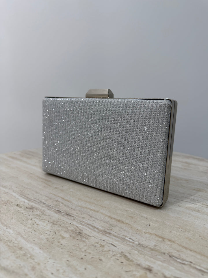 Pochette de soirée argentée pailletée élégante avec anse main et bandoulière chaîne. Idéale pour mariage, cérémonie et soirée chic.