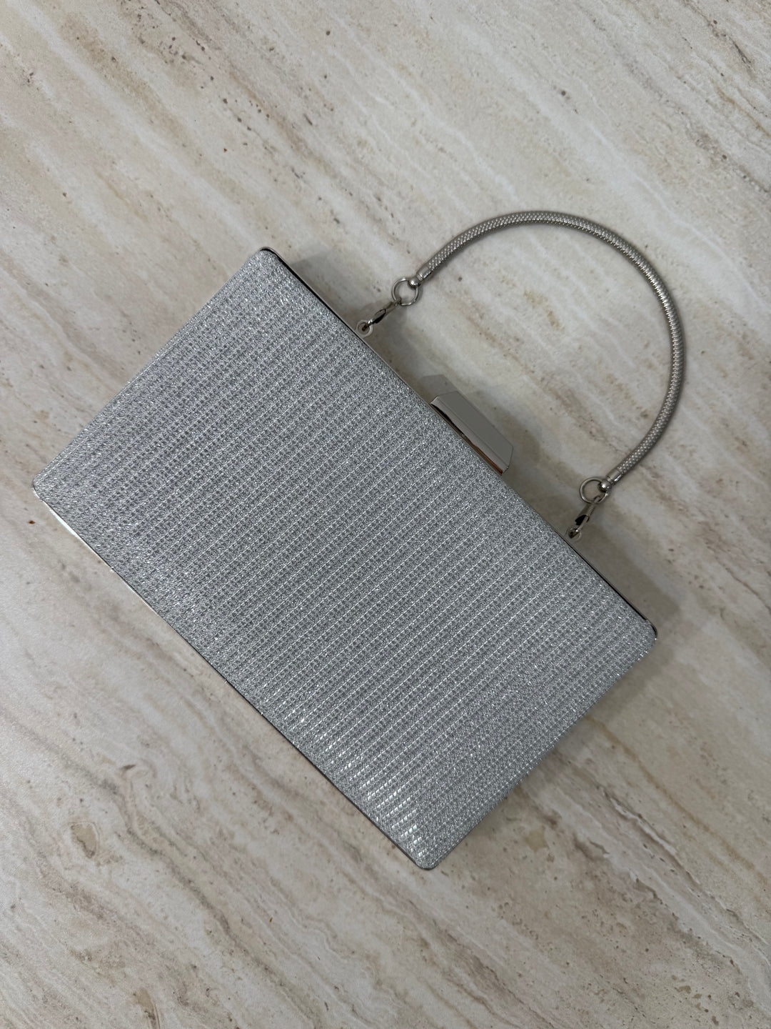 Pochette de soirée argentée pailletée élégante avec anse main et bandoulière chaîne. Idéale pour mariage, cérémonie et soirée chic.