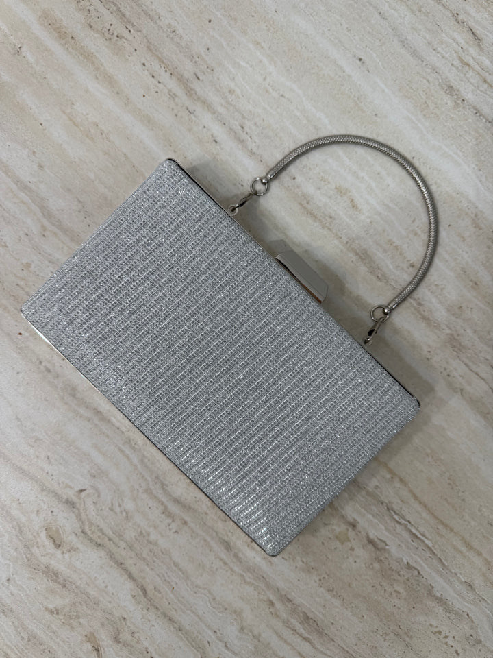 Pochette de soirée argentée pailletée élégante avec anse main et bandoulière chaîne. Idéale pour mariage, cérémonie et soirée chic.