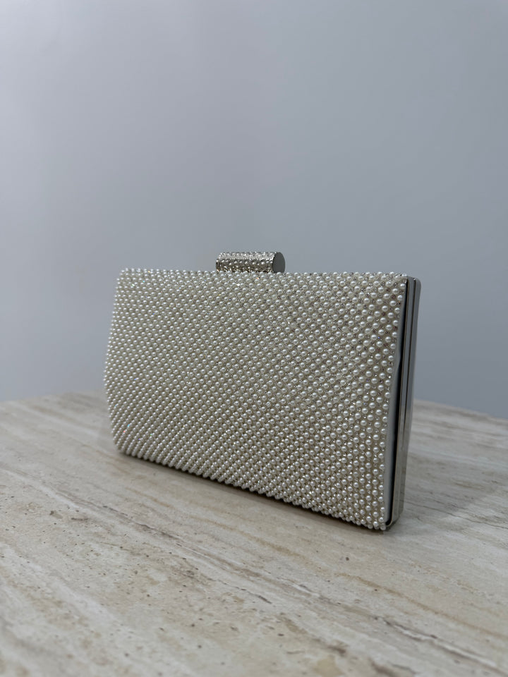 Pochette de soirée blanche strassée avec anse main et bandoulière chaîne. Double face perles et lisse, idéale pour mariage et cérémonie.