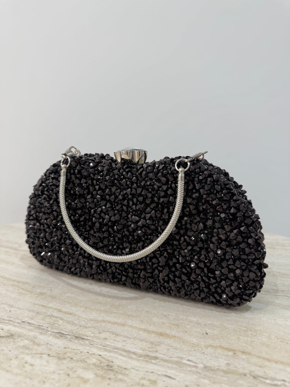 Pochette de soirée noire strassée élégante avec anse main et bandoulière chaîne. Idéale pour mariage, soirée et cérémonie chic.