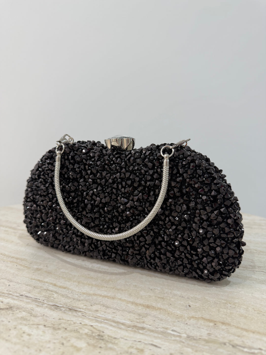 Pochette de soirée noire strassée élégante avec anse main et bandoulière chaîne. Idéale pour mariage, soirée et cérémonie chic.