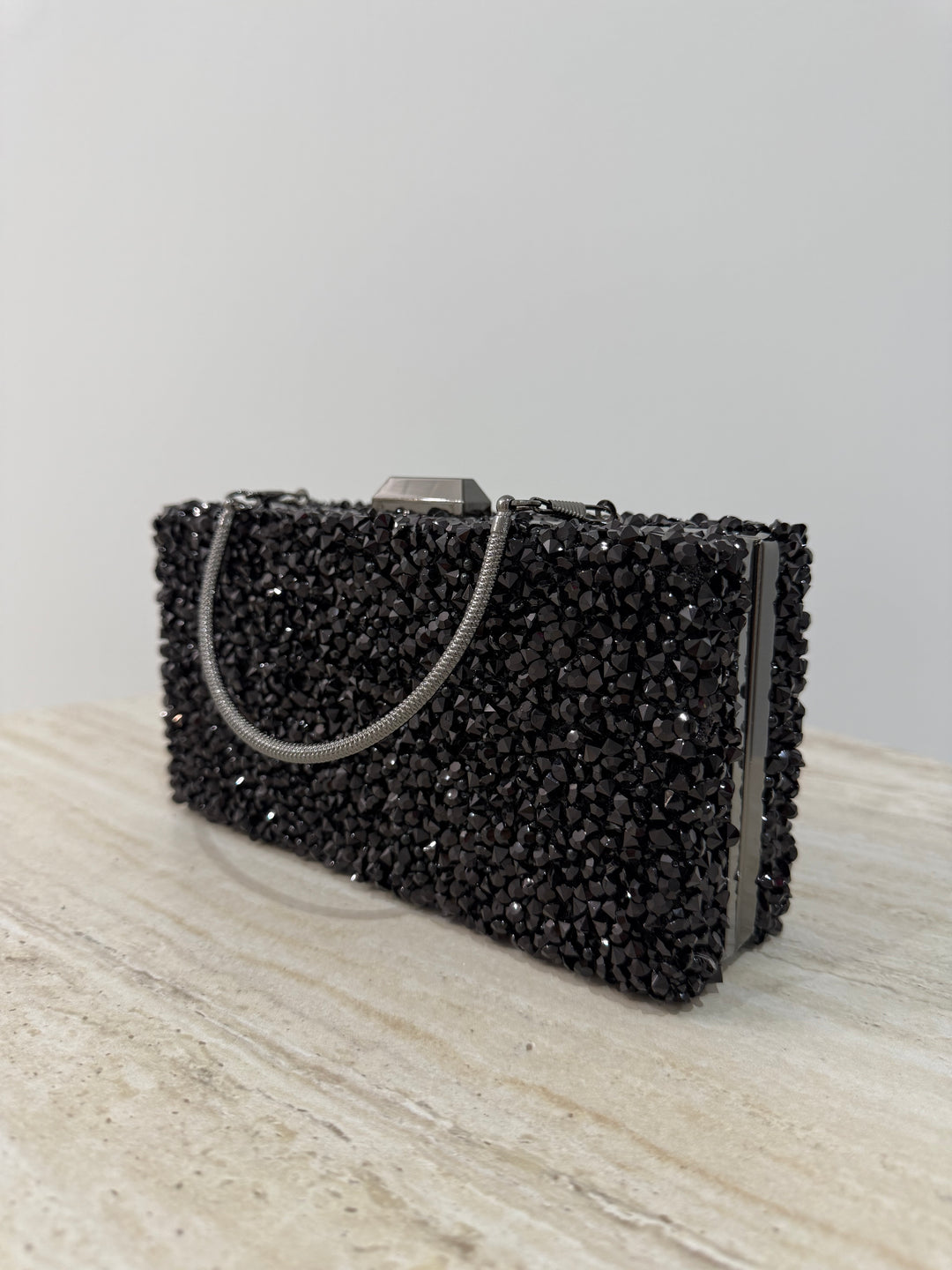 Pochette de soirée noire strassée élégante avec anse main et bandoulière chaîne. Idéale pour mariage, soirée et cérémonie chic.