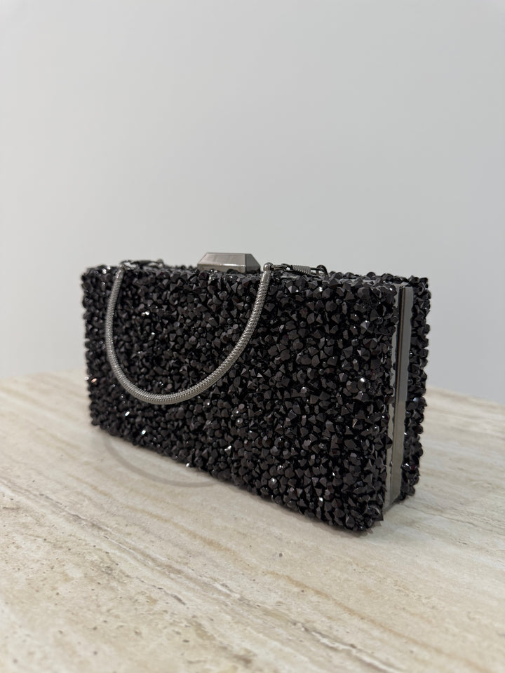 Pochette de soirée noire strassée élégante avec anse main et bandoulière chaîne. Idéale pour mariage, soirée et cérémonie chic.