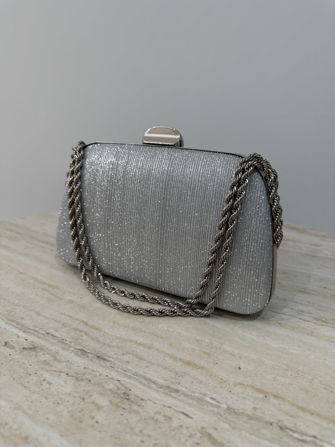 Pochette de soirée argentée élégante avec anse main et bandoulière chaîne. Idéale pour mariage, cérémonie et soirée chic.