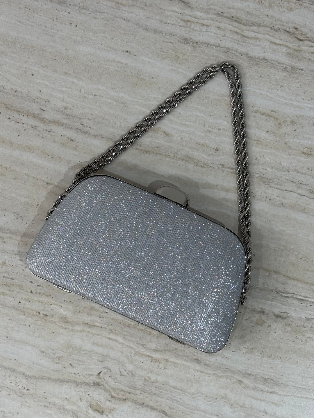 Pochette de soirée argentée élégante avec anse main et bandoulière chaîne. Idéale pour mariage, cérémonie et soirée chic.