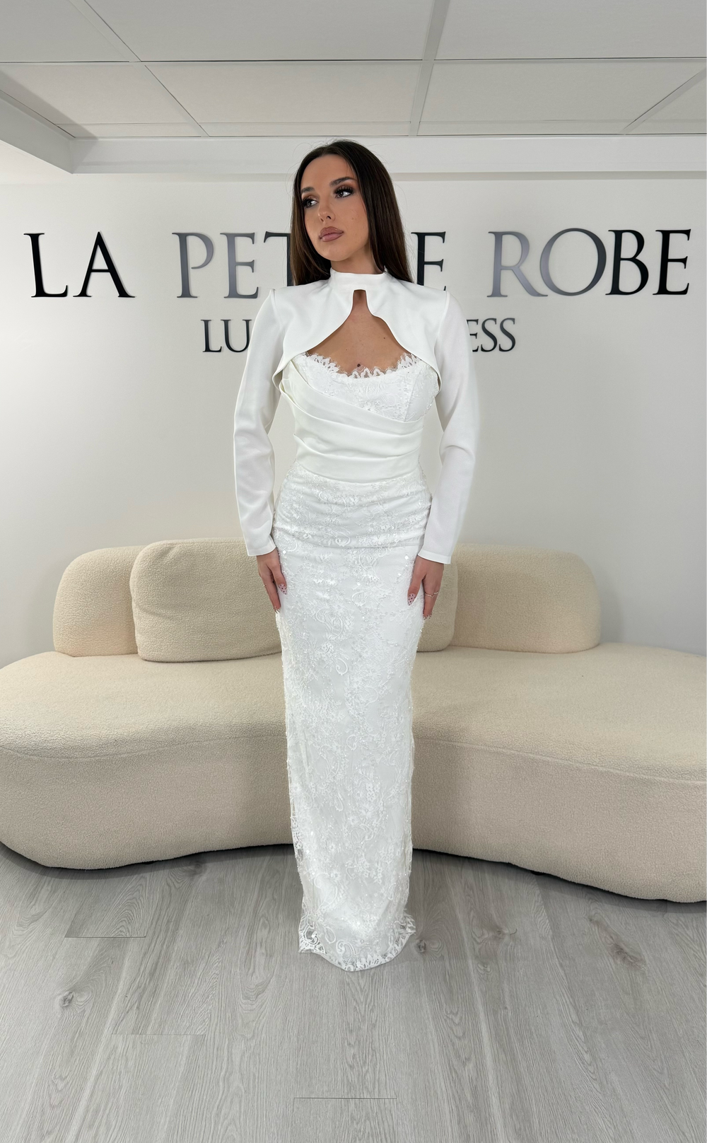 Robe de mariée blanche longue avec manches longues et boléro amovible. Une robe élégante sans fente avec détails en dentelle, idéale pour un mariage chic.