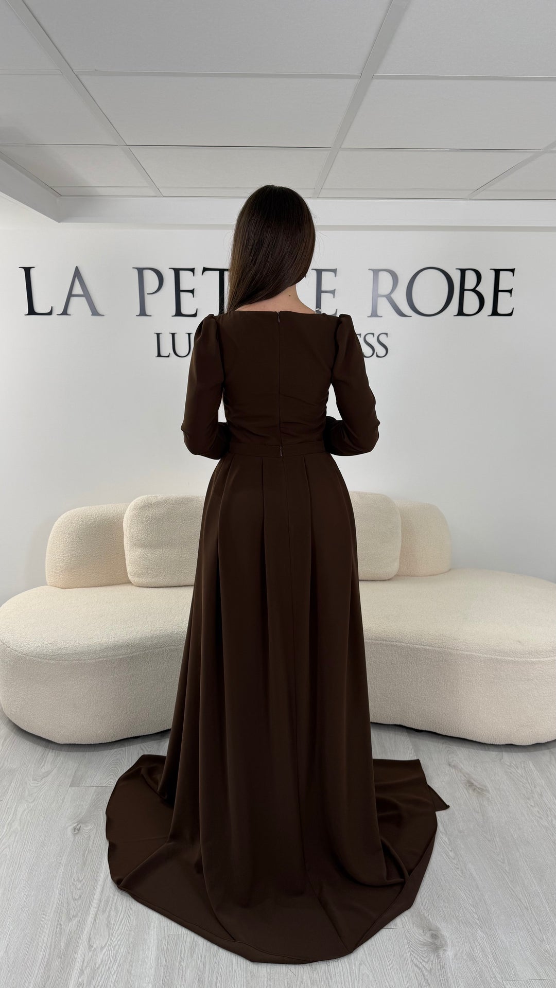 Robe de soirée marron élégante avec col rond et manches longues. Robe longue sans fente, coupe raffinée et détails perlés pour une tenue chic idéale pour soirée et gala.