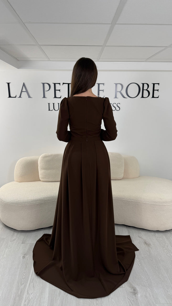 Robe de soirée marron élégante avec col rond et manches longues. Robe longue sans fente, coupe raffinée et détails perlés pour une tenue chic idéale pour soirée et gala.