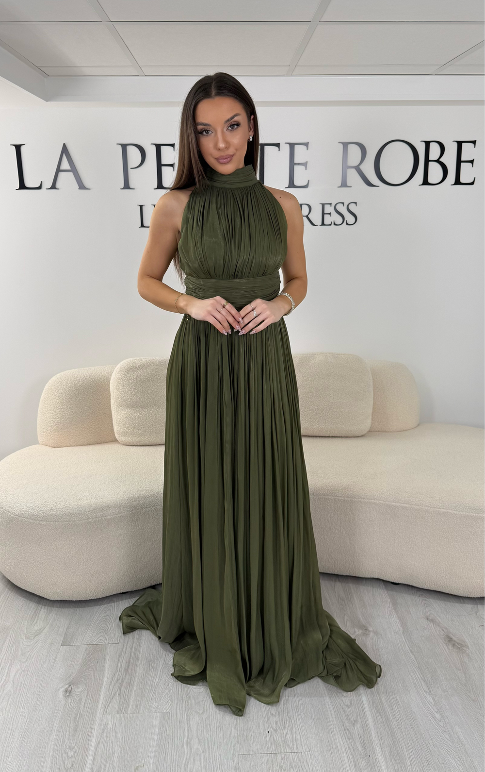 Robe de soirée kaki longue plissée avec col montant et coupe sans manches. Une robe élégante sans fente idéale pour mariage, cérémonie et soirée chic.